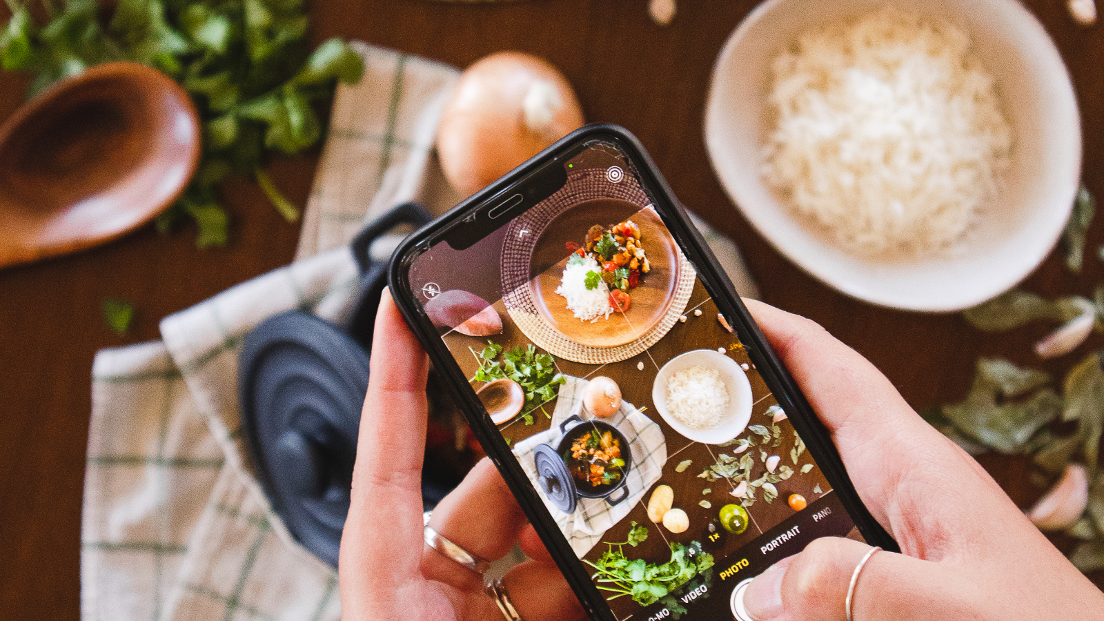 mobile phone taking photo of food on table